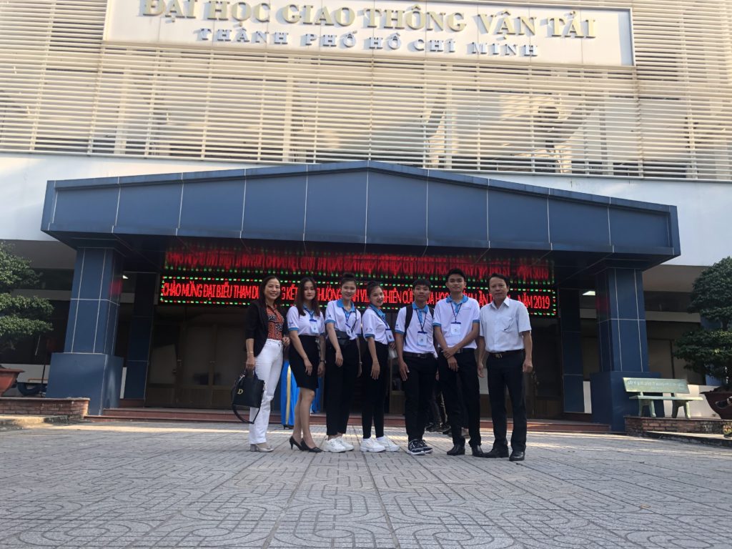 A group of people standing in front of a buildingDescription automatically generated