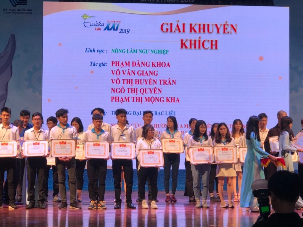 A group of people on a stage holding certificatesDescription automatically generated