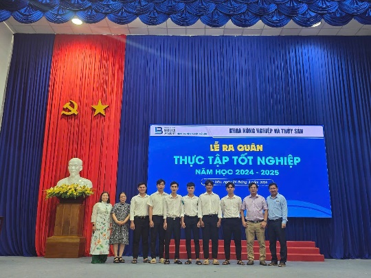 A group of people standing in front of a blue and red curtainAI-generated content may be incorrect.
