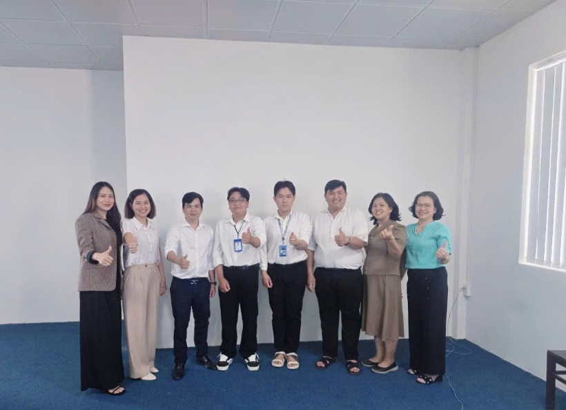 A group of people standing in a roomDescription automatically generated